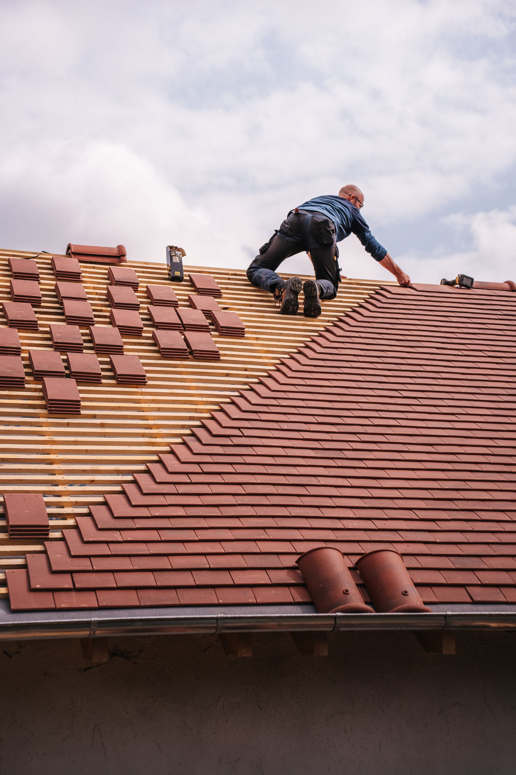 Roofer installing shingles on a pitched roof